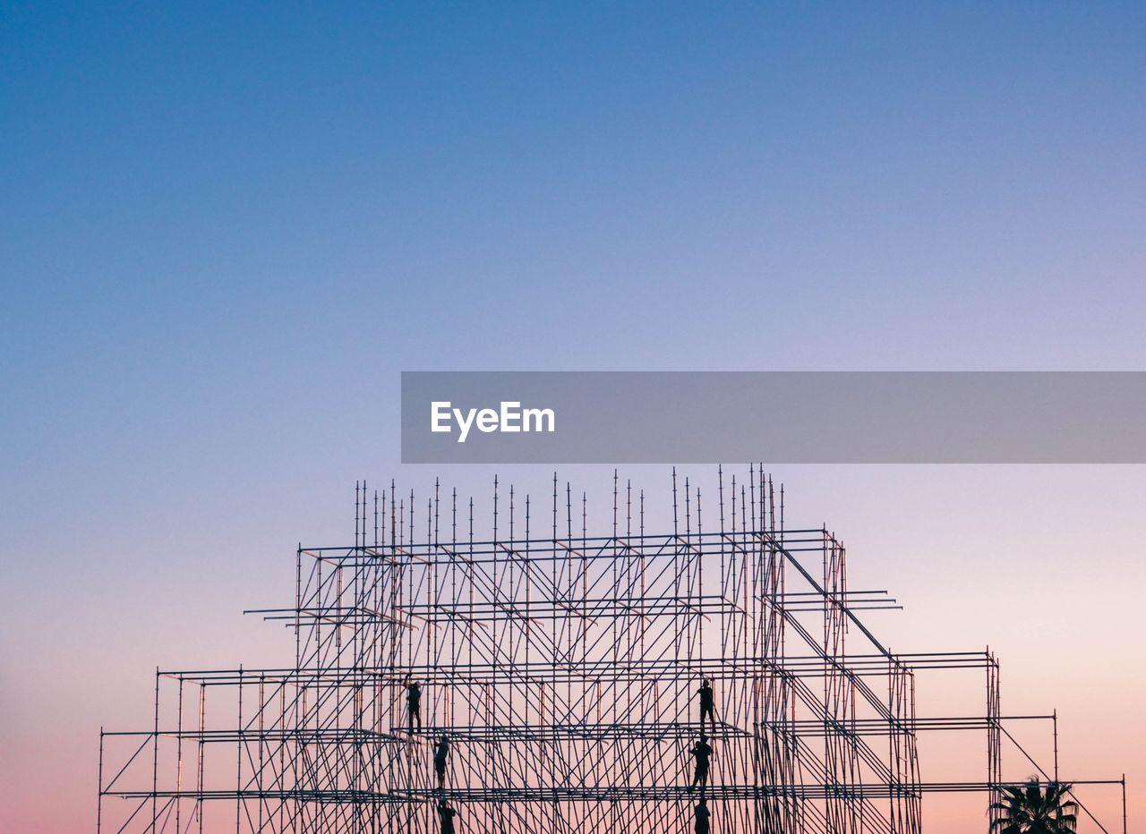 low angle view of electricity pylon against clear sky during sunset