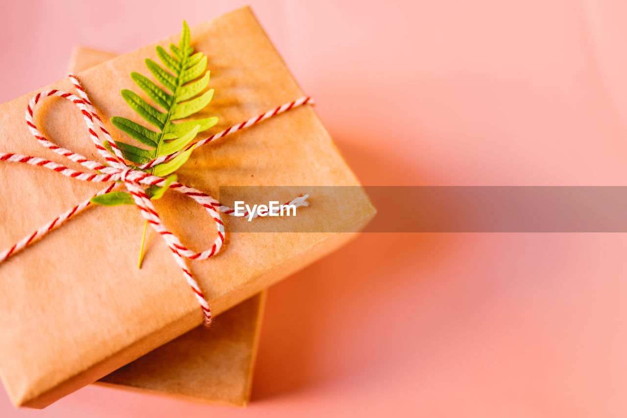 CLOSE-UP OF PAPER TIED UP ON PINK FABRIC