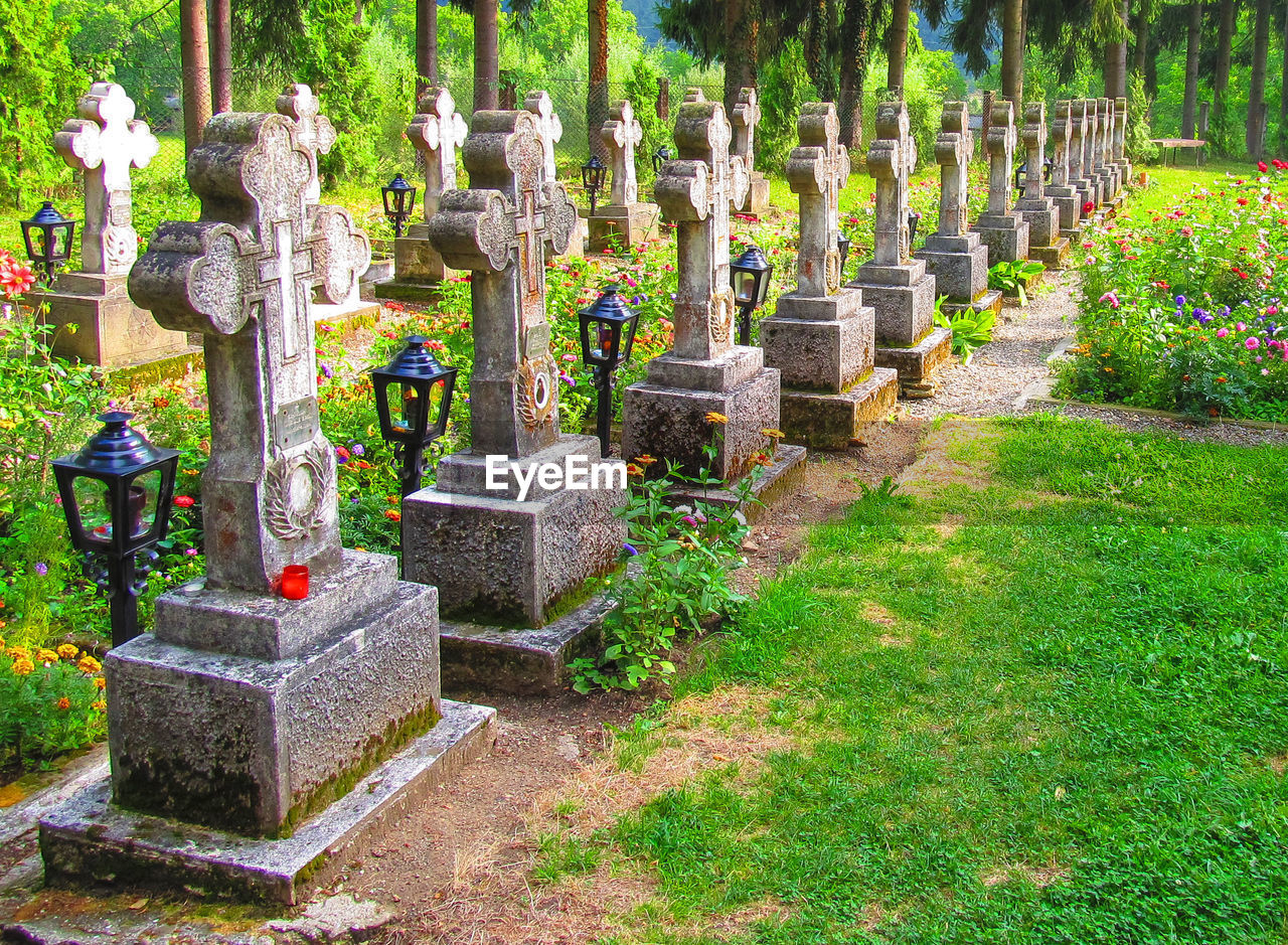 STONE CROSS IN CEMETERY AGAINST TEMPLE