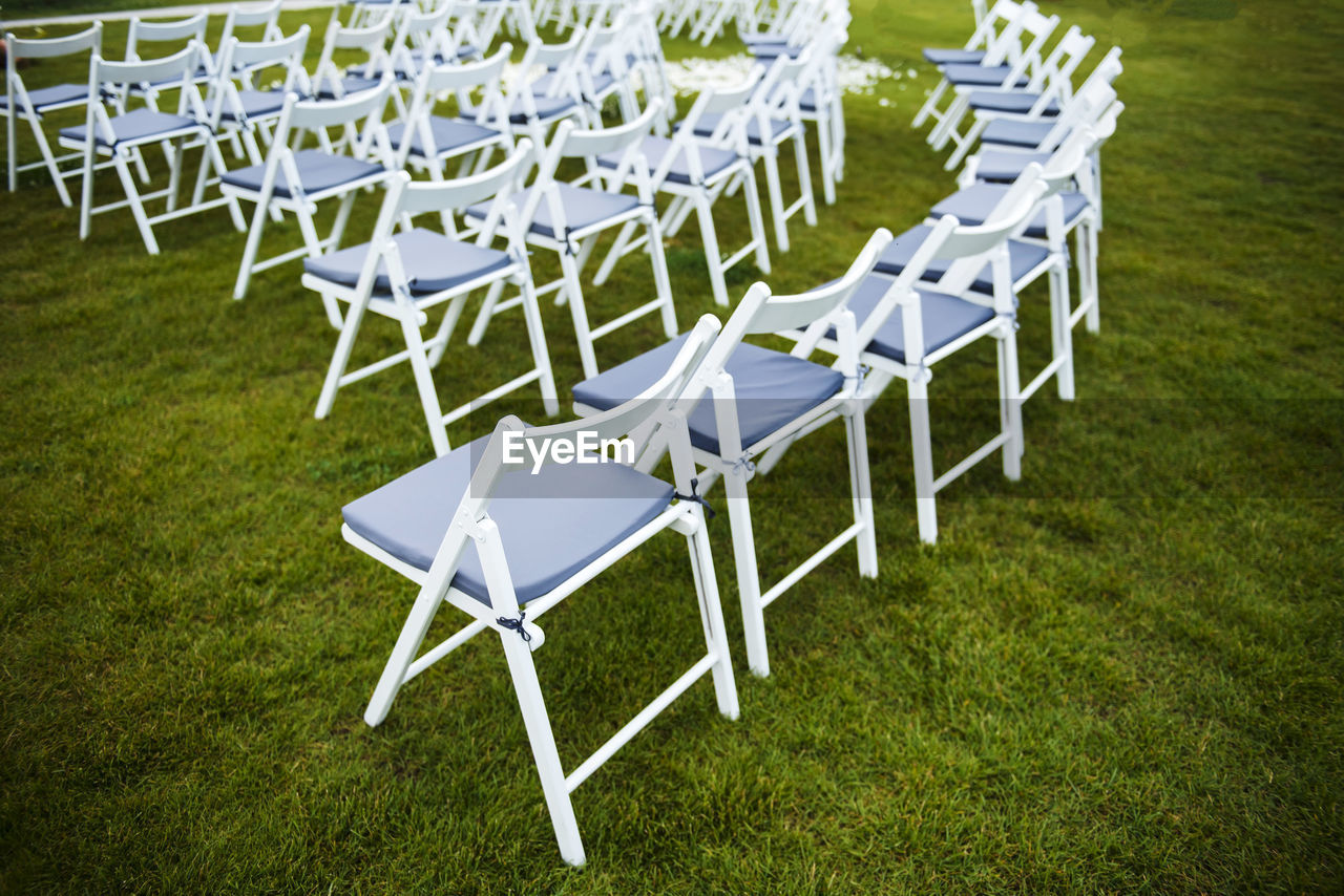 High angle view of empty chairs and table on field