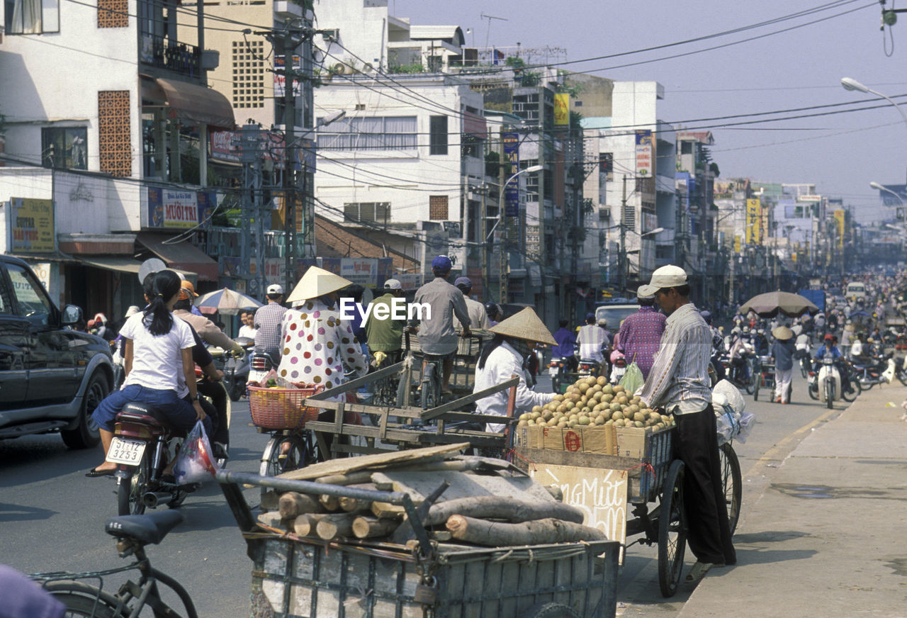 People on road against buildings in city