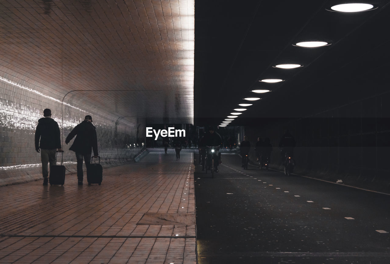 REAR VIEW OF PEOPLE WALKING ON SUBWAY STATION