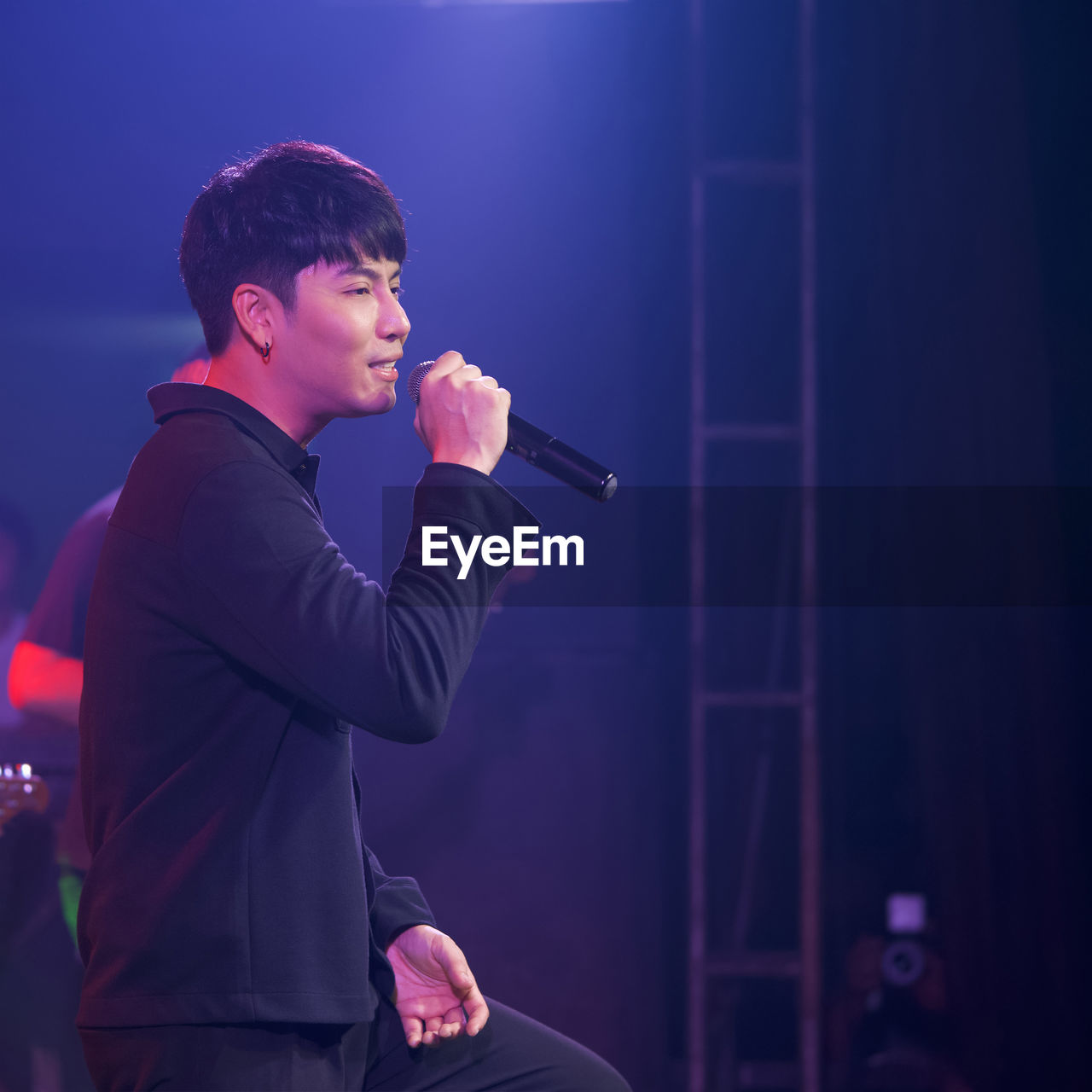 Side view of young man standing at music concert