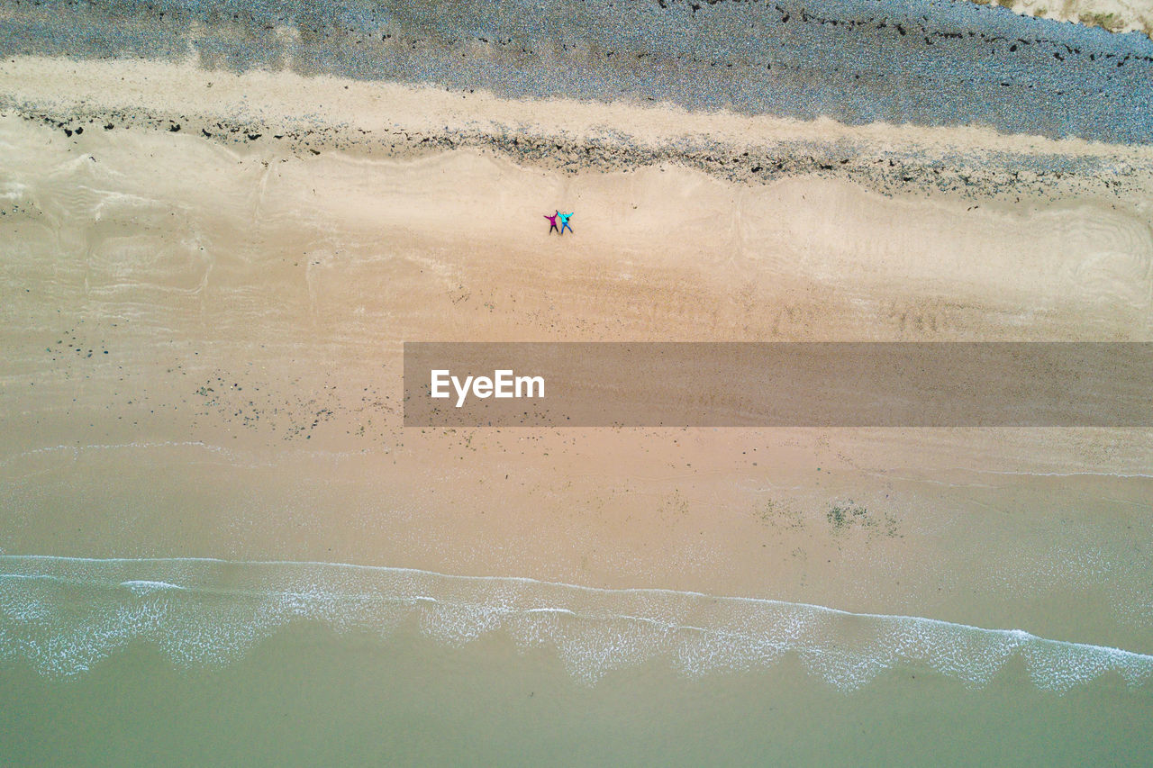 Aerial view of couple lying at beach