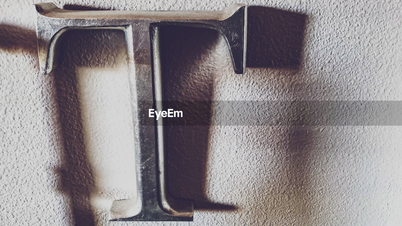 HIGH ANGLE VIEW OF METAL ON TABLE BY WALL