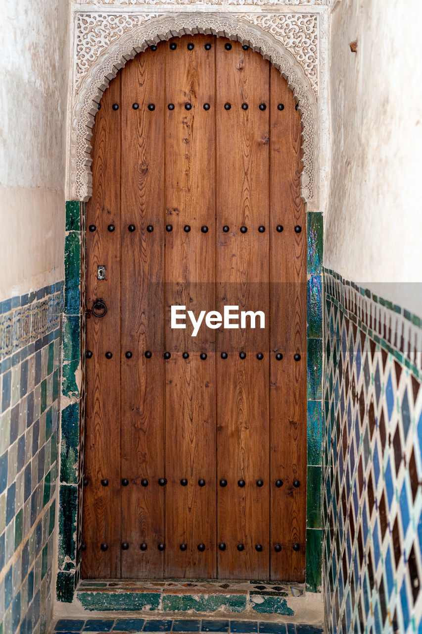 Closed arabesque door in the palace of the alhambra in granada, spain