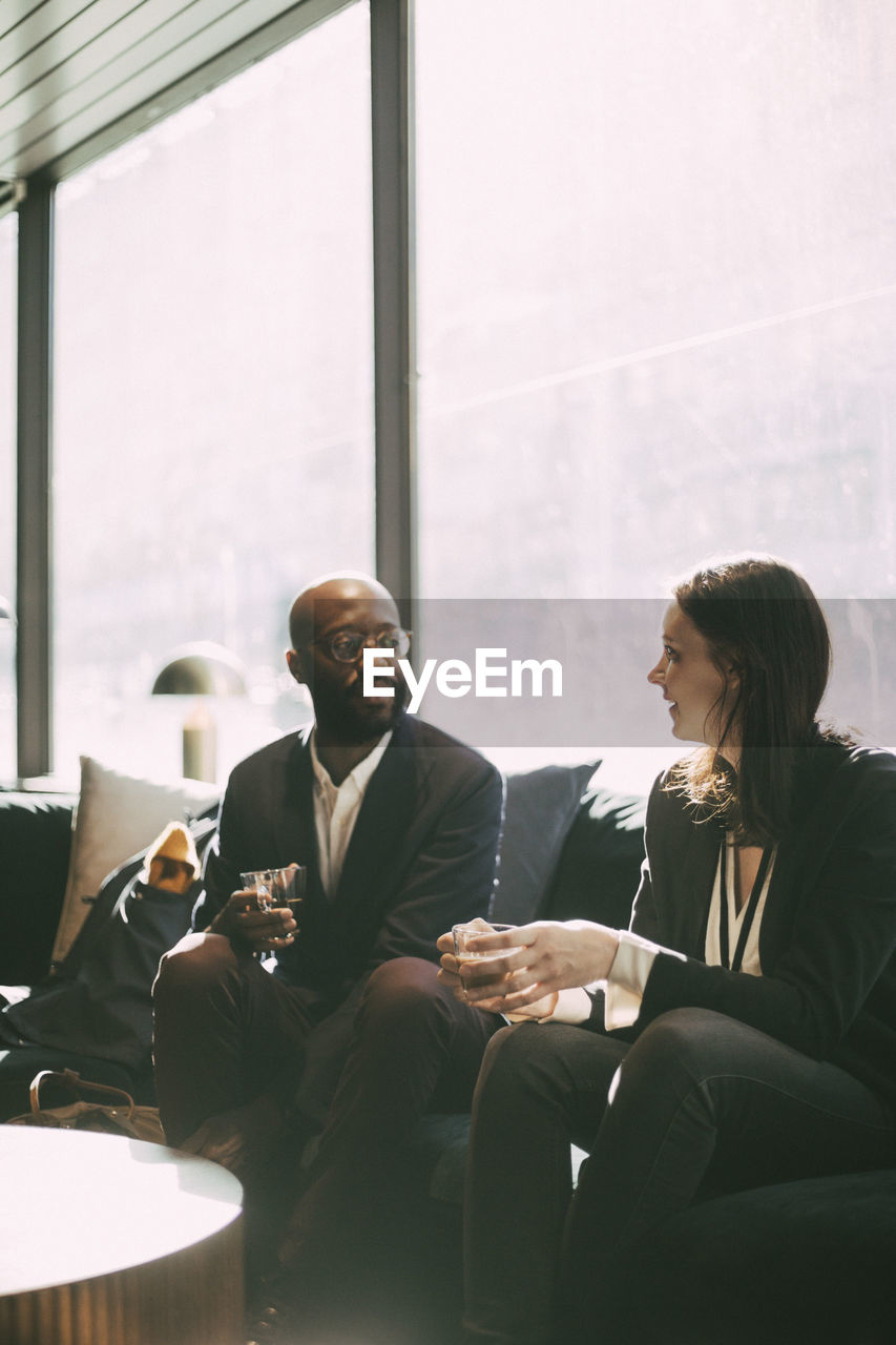 Business professionals with drinking glass sitting in office