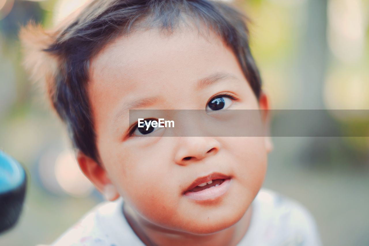 Happy toddler with innocent expression making eye contact, smiling. close-up headshot portrait