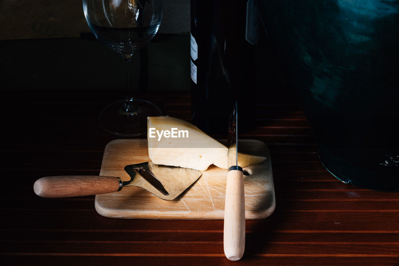 High angle view of cheese by wine bottle on table