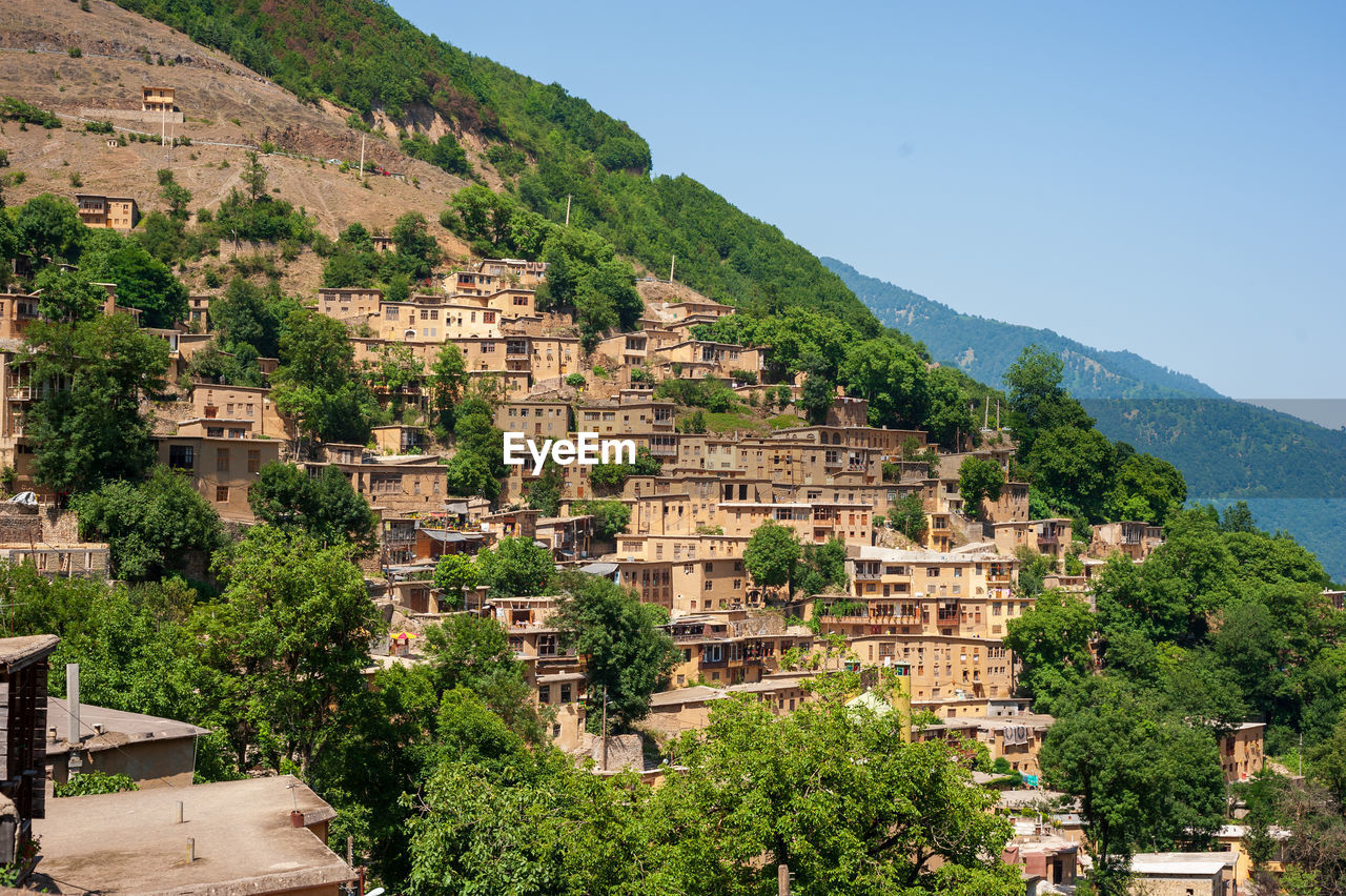 HIGH ANGLE VIEW OF BUILDINGS IN TOWN AGAINST CLEAR SKY