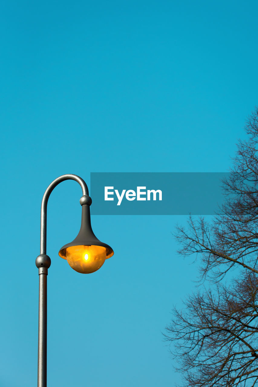 Low angle view of street light against clear blue sky