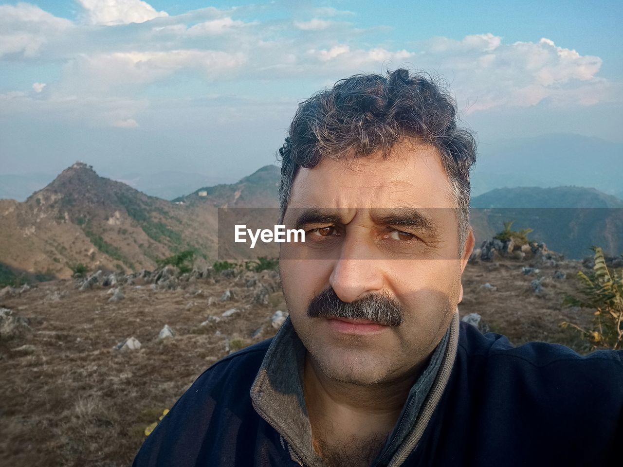 Portrait of man in mountains against sky