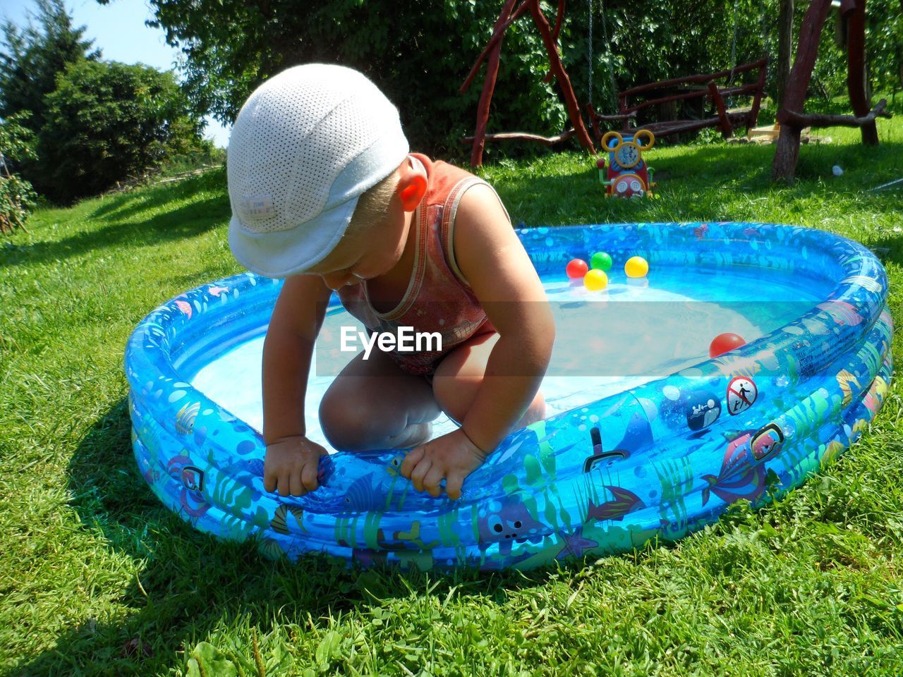 GIRL PLAYING WITH BALL ON SWIMMING POOL