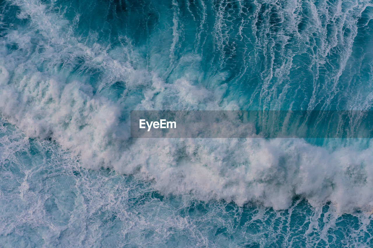 Aerial view of waves splashing in sea