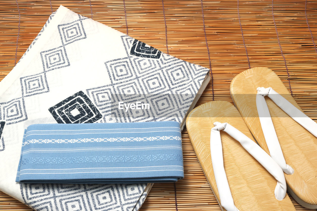 High angle view of fabrics with flip-flops on table