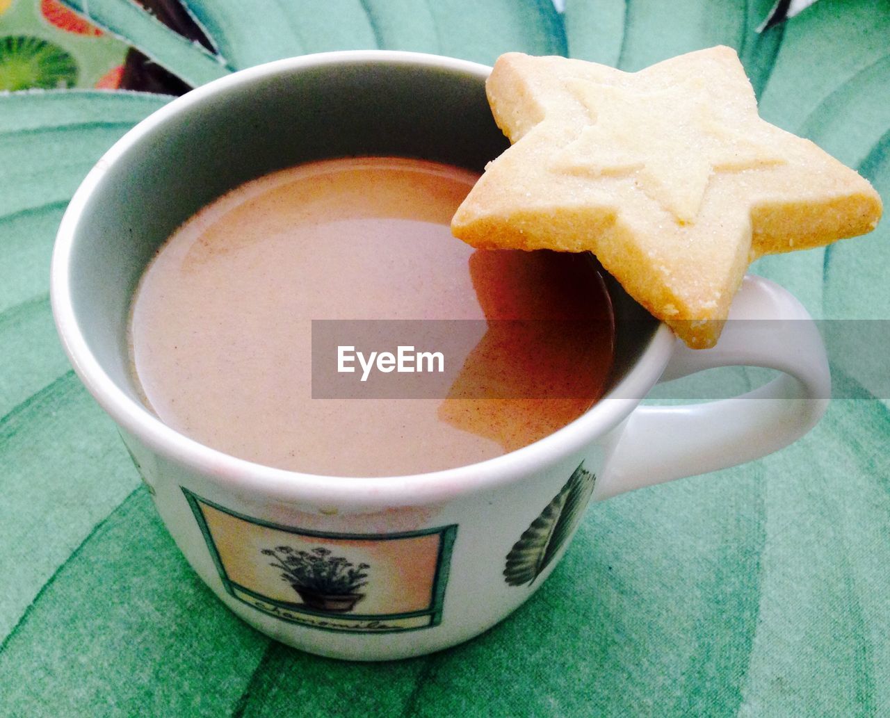 Close-up of coffee with star shape cookie served on table