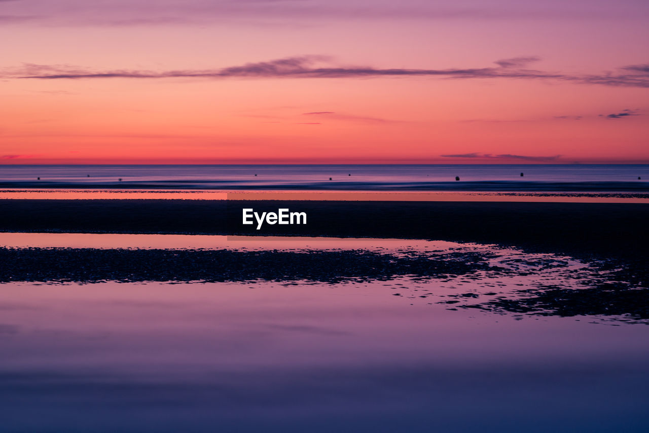 Colorful sunset at the beach with sand banks in the foreground at low tide