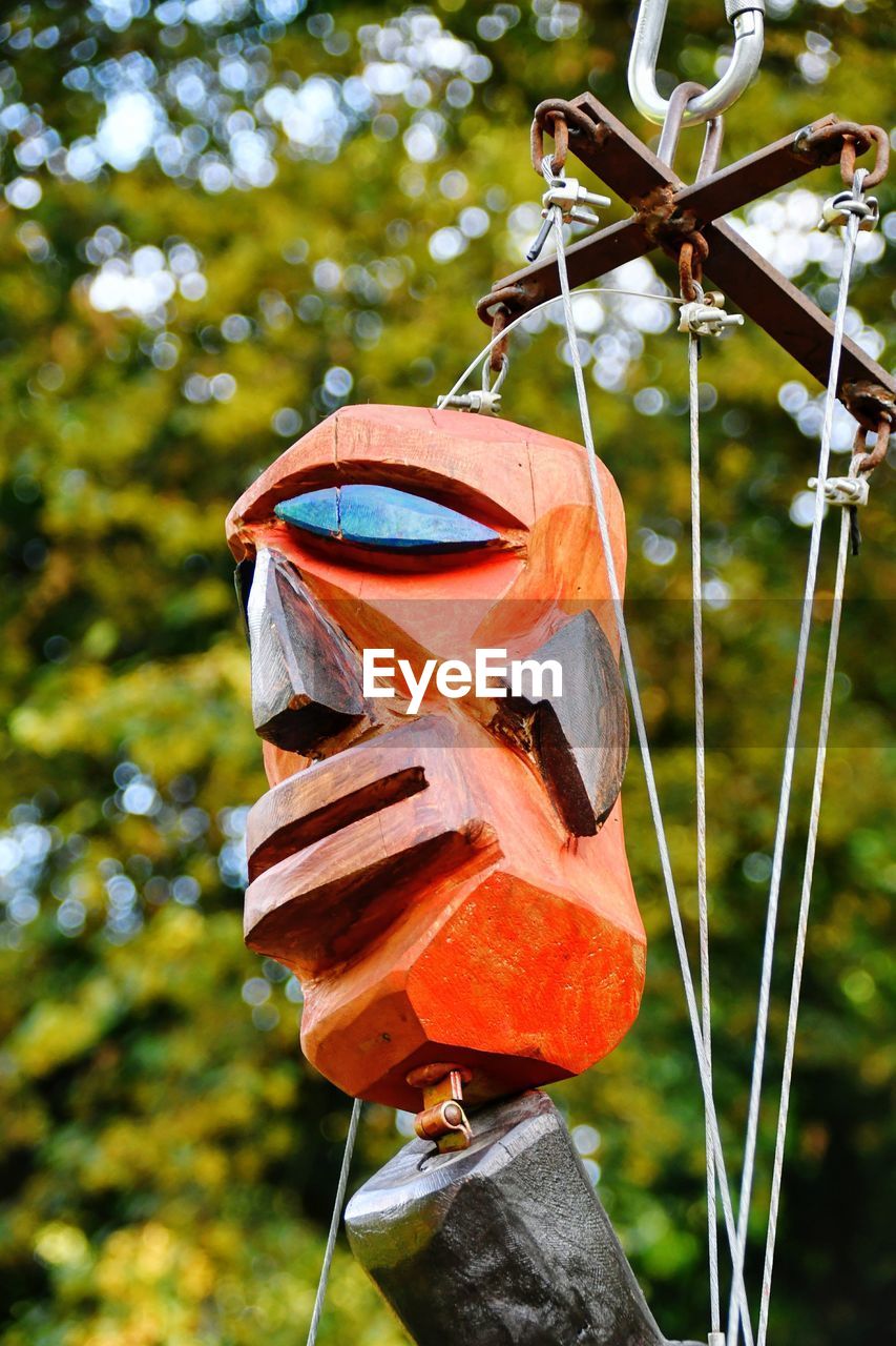 Close-up of toy hanging on pole in field