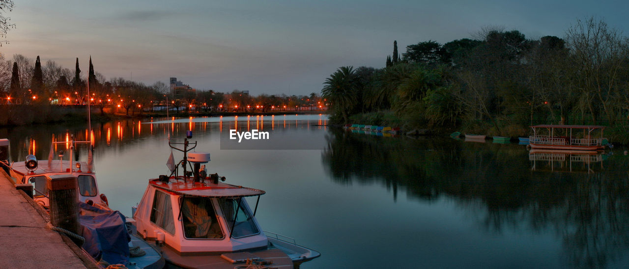 Boats moored in lake against sky