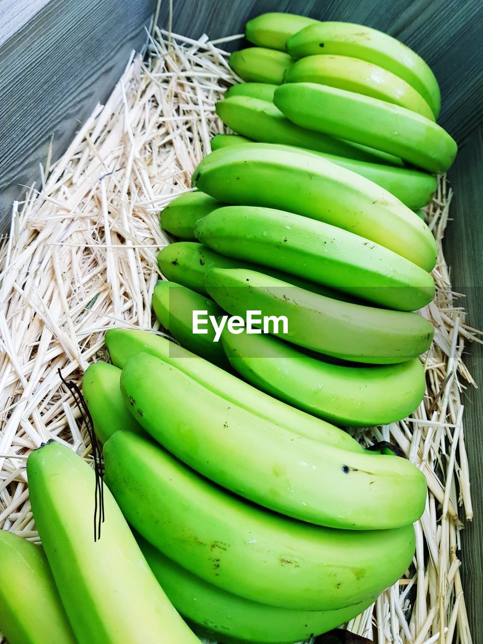 High angle view of unripe bananas in basket