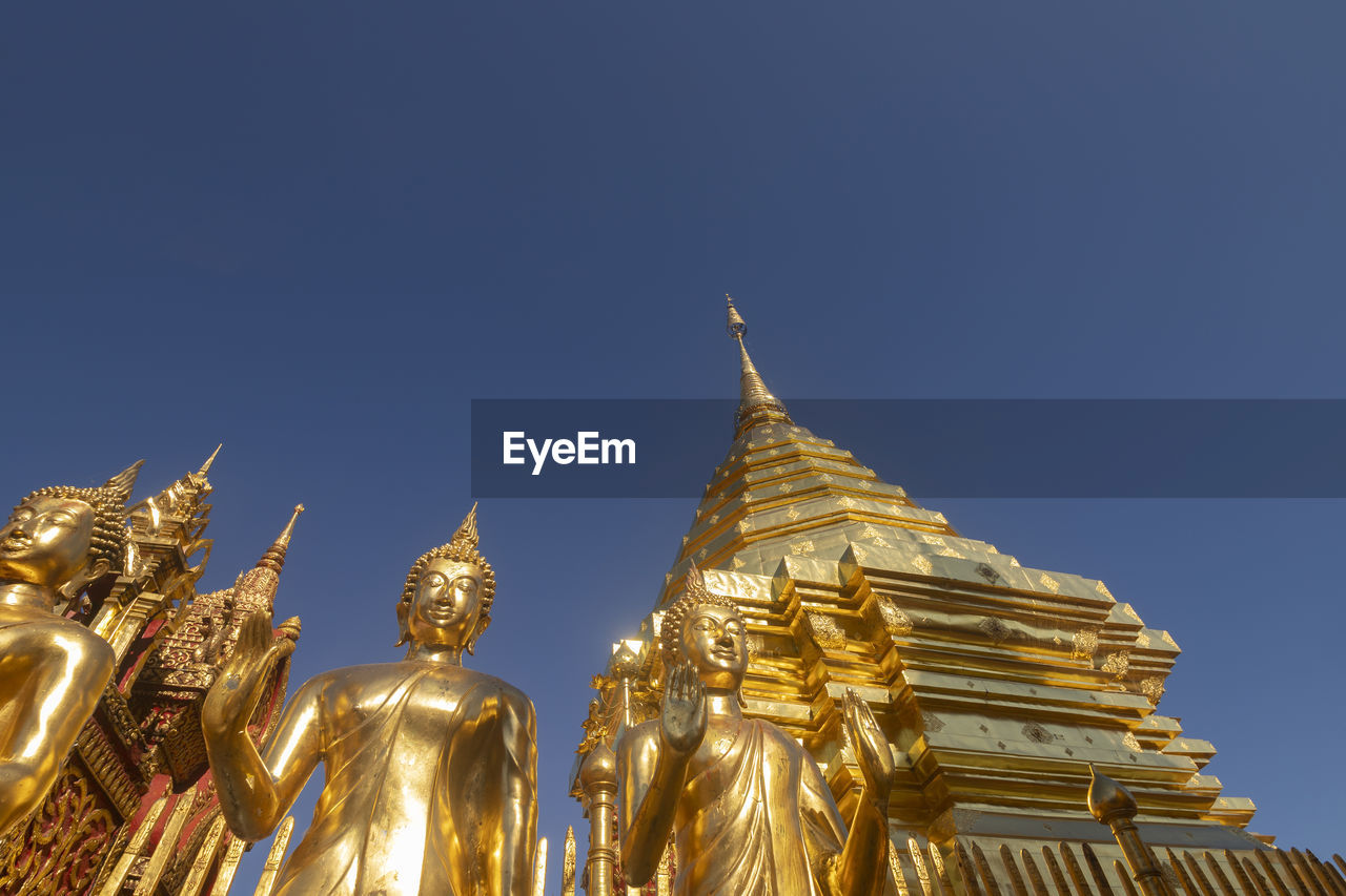 LOW ANGLE VIEW OF STATUE AGAINST ILLUMINATED BUILDINGS AGAINST CLEAR SKY