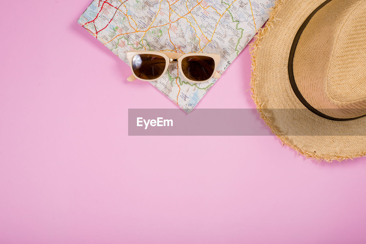 HIGH ANGLE VIEW OF SUNGLASSES ON PINK PAPER