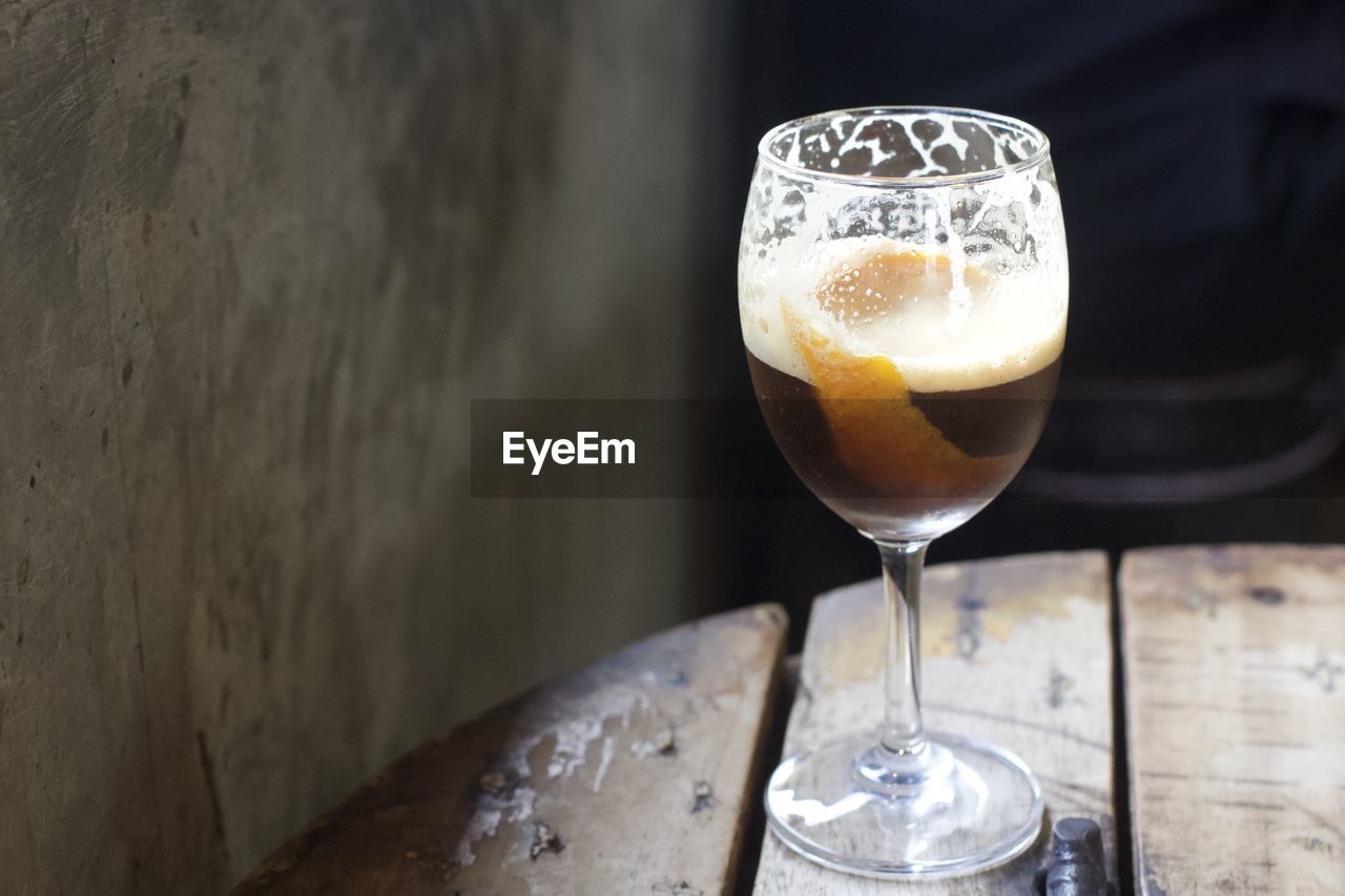 CLOSE-UP OF BEER IN GLASS ON TABLE