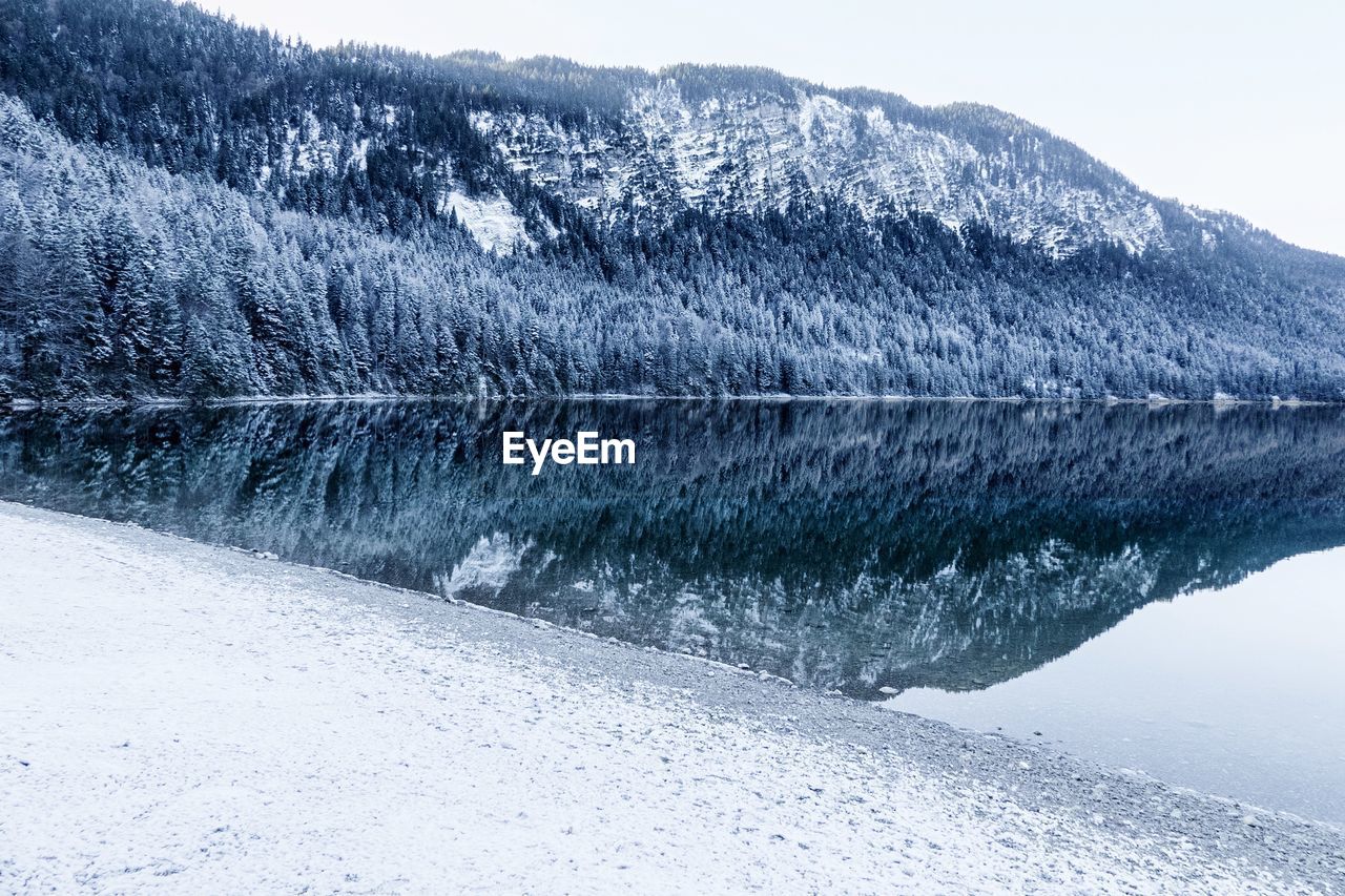 Scenic view of lake by snow covered mountain