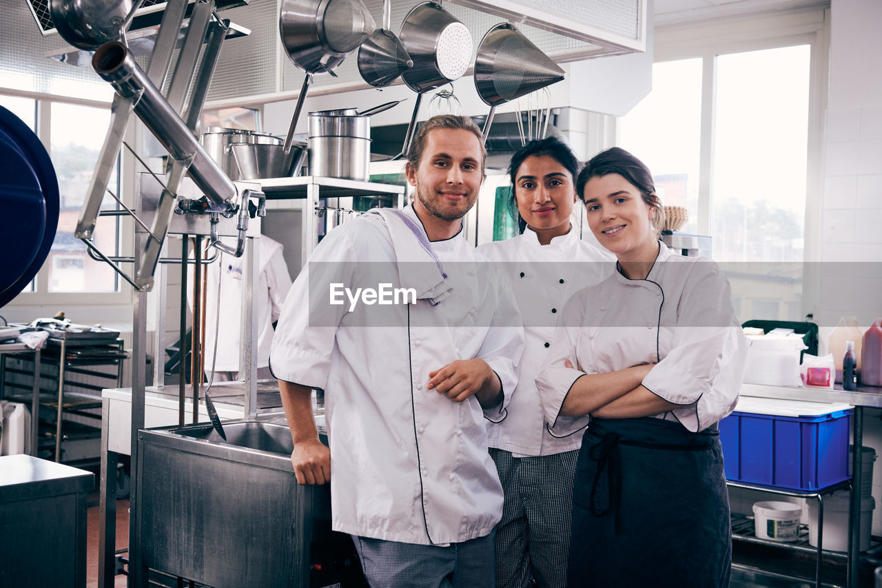 Portrait of multi-ethnic chefs standing in commercial kitchen