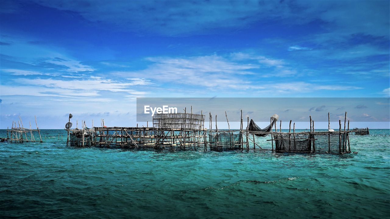 Pier over sea against blue sky