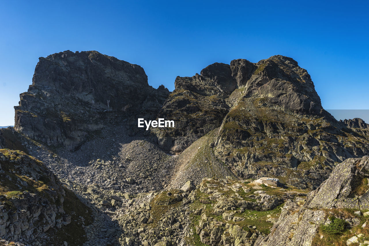 Rock formation against clear blue sky