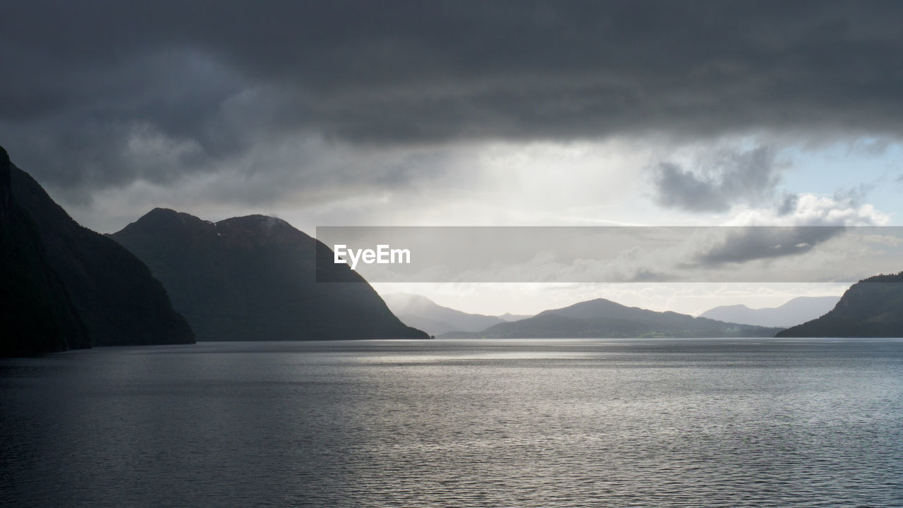 Scenic view of sea and mountains against sky