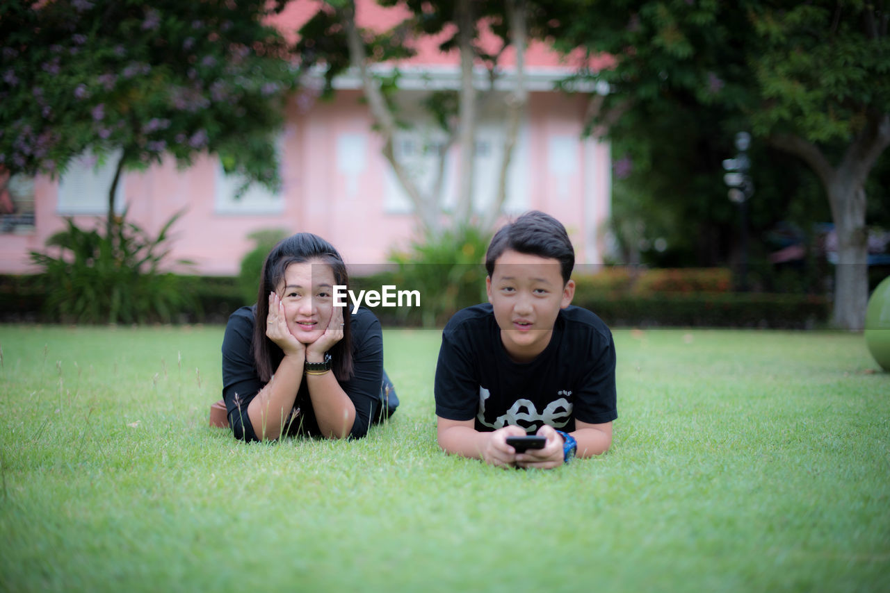 Portrait of mother and son lying on grass