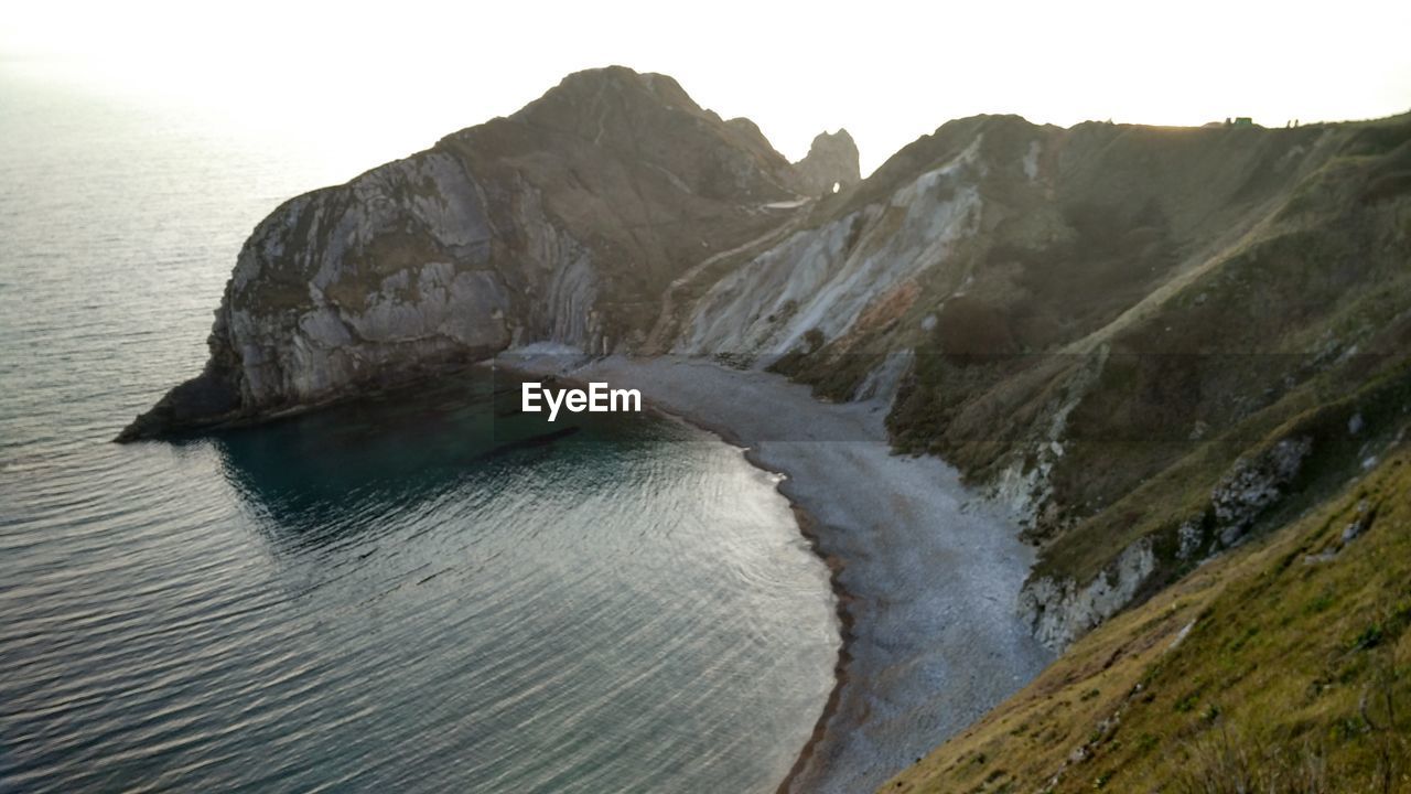 Scenic view of sea and mountains against sky