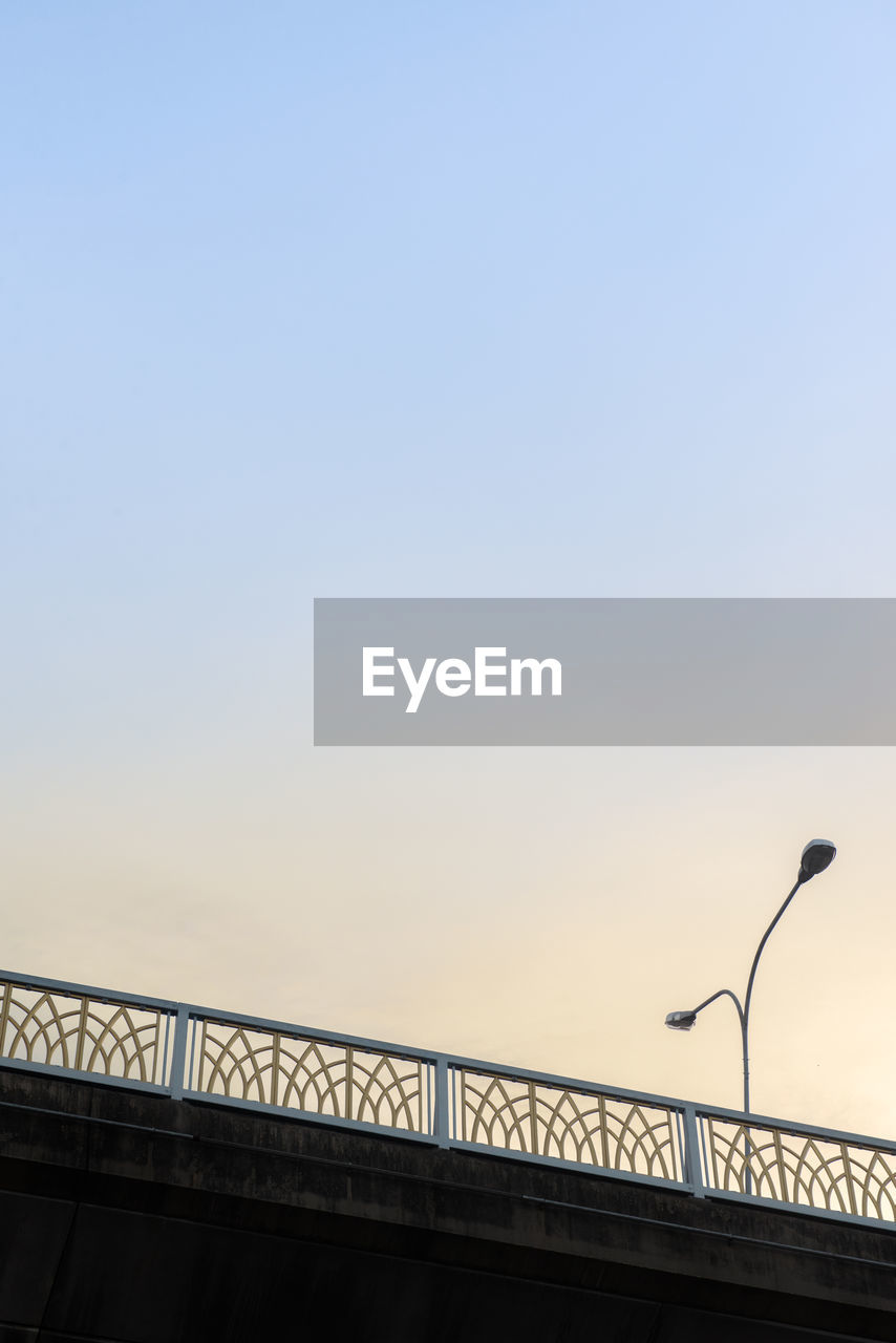 LOW ANGLE VIEW OF BRIDGE AGAINST SKY DURING SUNSET