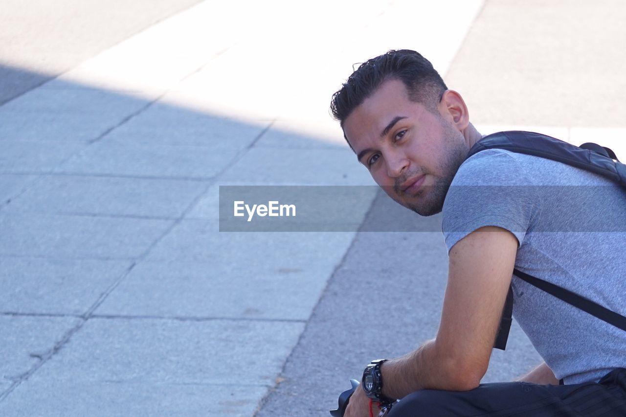 Portrait of man bending at footpath