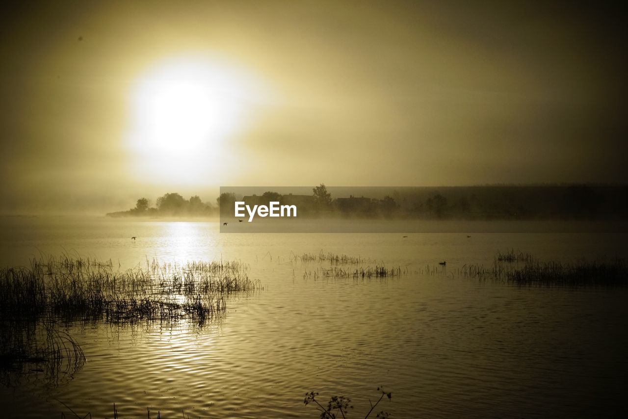 Scenic view of lake against sky during sunset