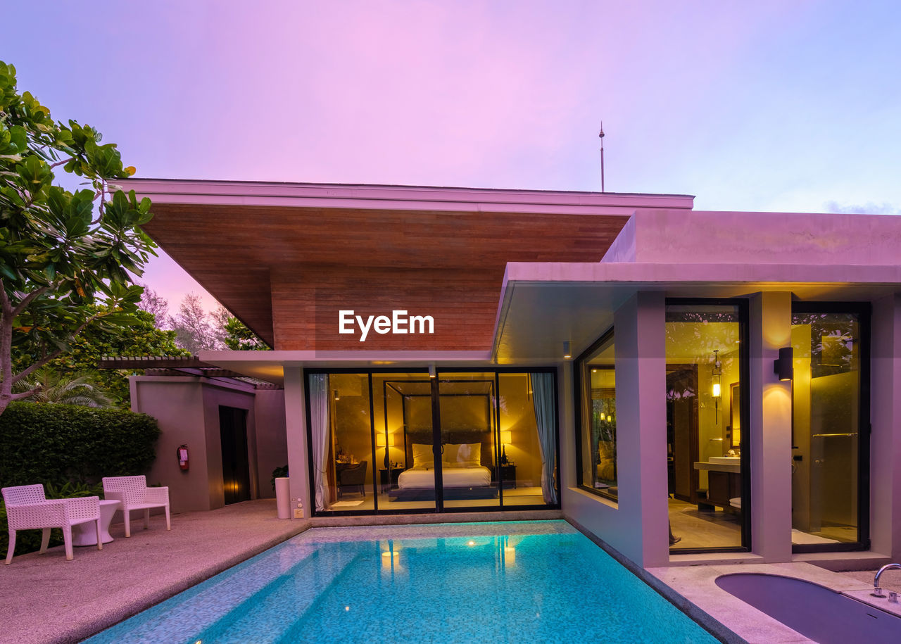 architecture, swimming pool, luxury, wealth, estate, built structure, building exterior, building, house, nature, home, water, residential district, dusk, night, villa, resort, mansion, no people, illuminated, tourist resort, entrance, outdoors, travel destinations, home ownership, real estate, relaxation, lifestyles, hotel, tranquility, summer, luxury hotel, tropical climate, front or back yard, door, poolside, blue, elegance, domestic life, patio, sunset