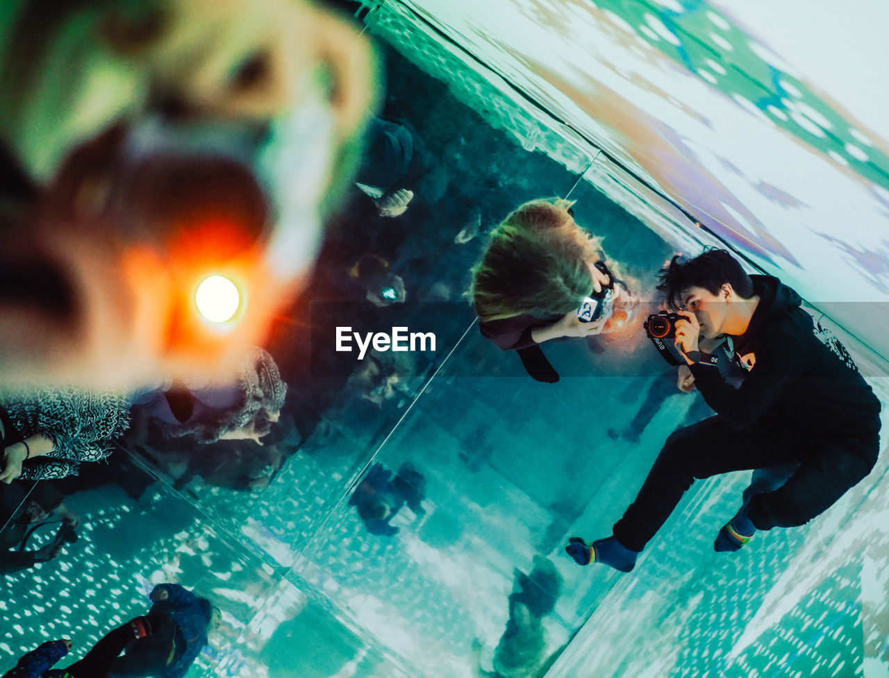 HIGH ANGLE VIEW OF PEOPLE SWIMMING IN POOL