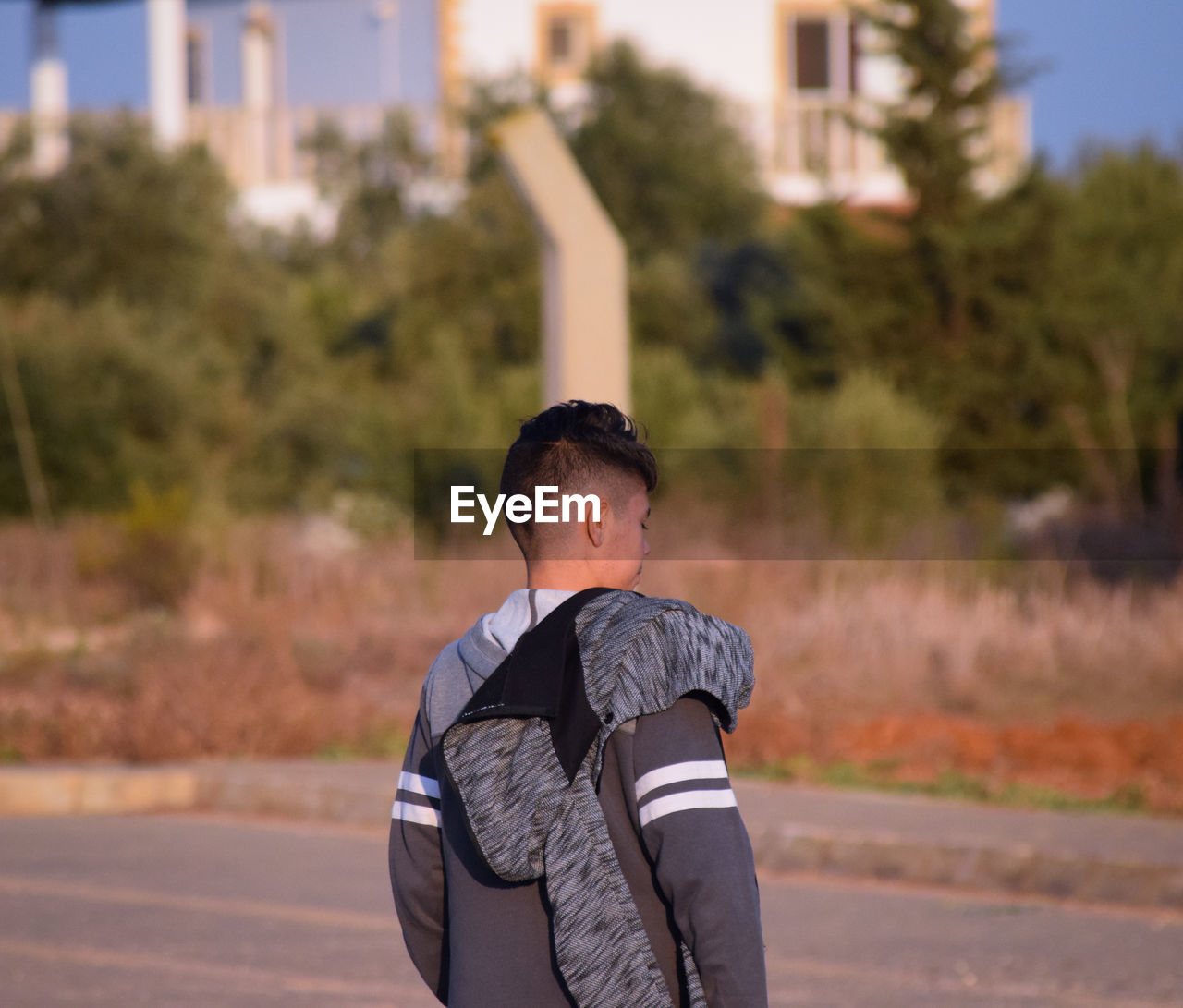 Rear view of boy standing on road