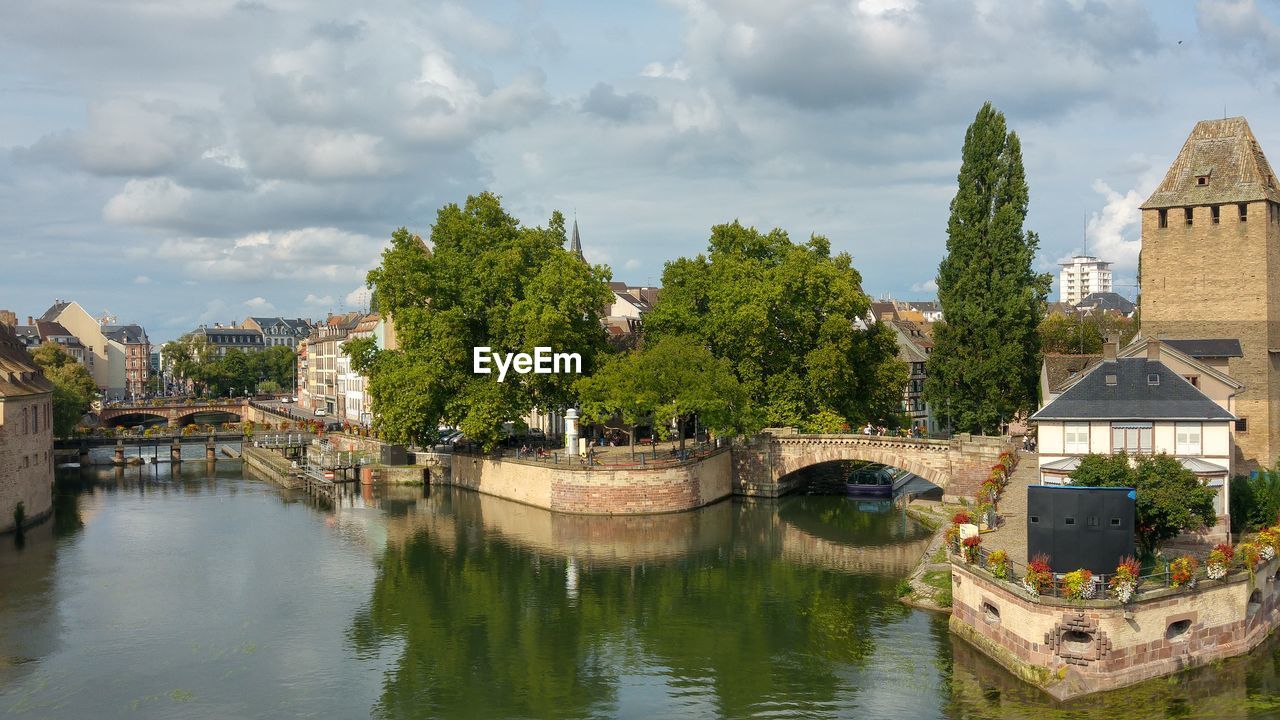 Panoramic view of bridge over river by buildings against sky