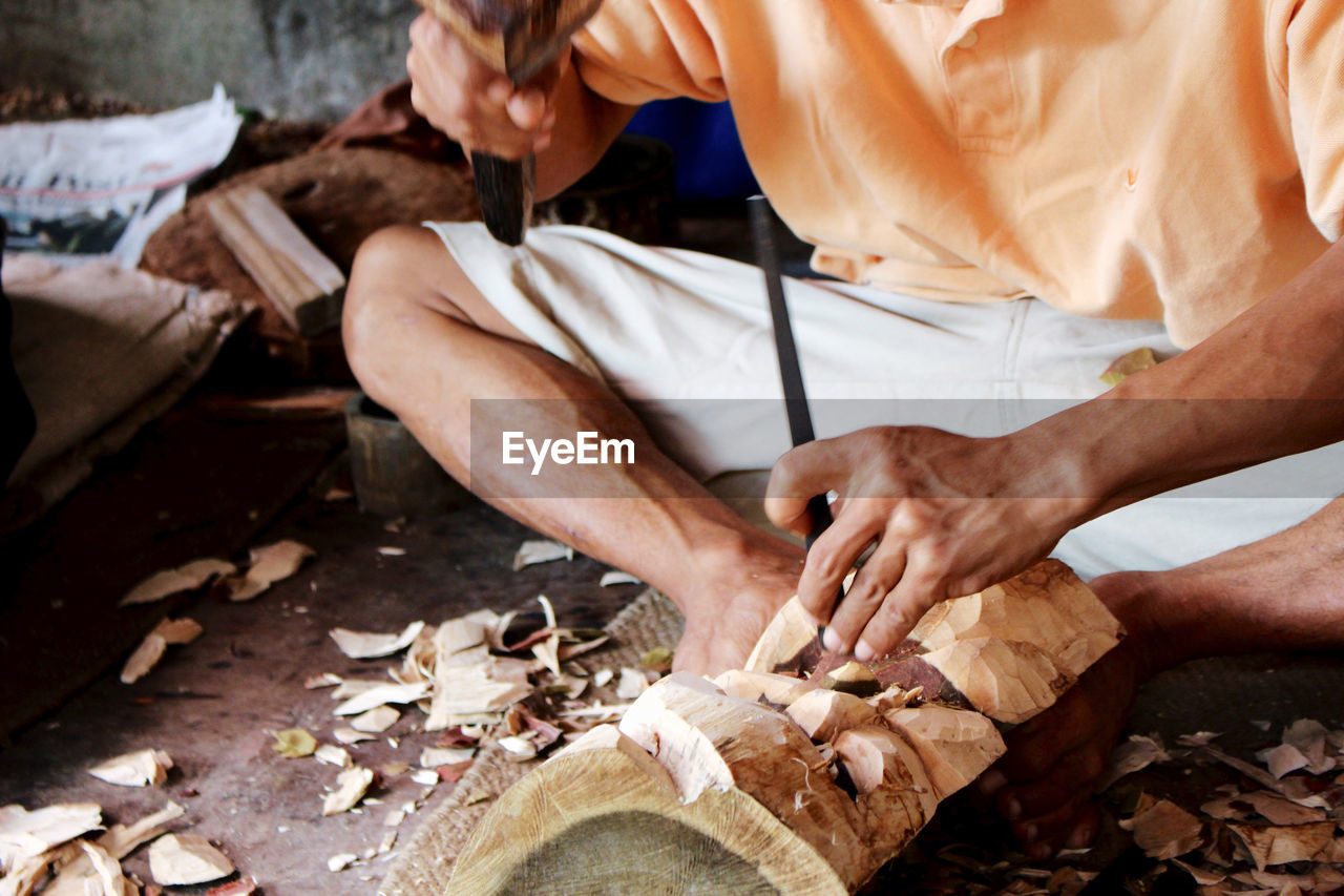 Low section of man carving in workshop