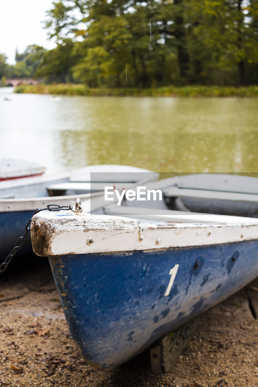 Close-up of old boat moored on shore