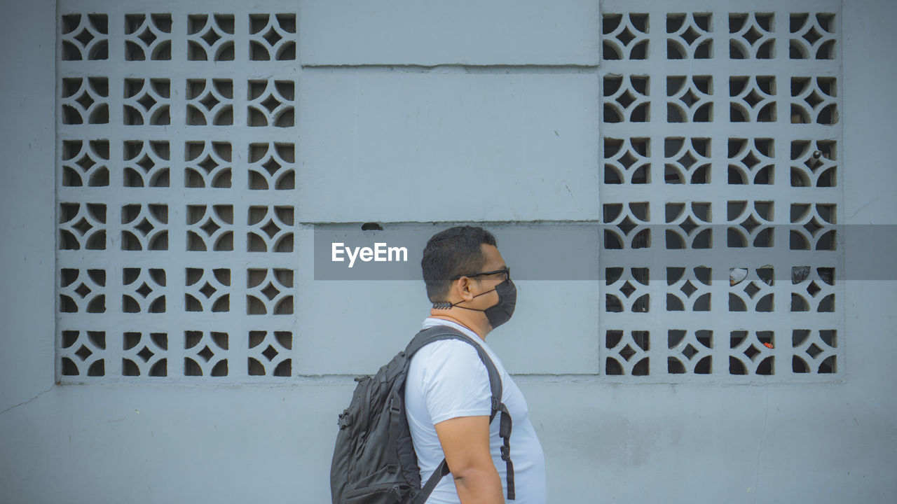 Man standing against wall