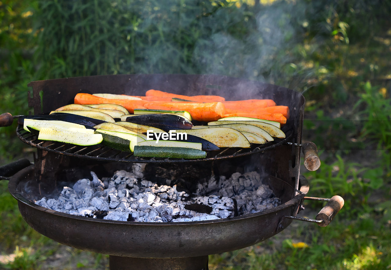 Vegetables cooking on barbecue grill in yard