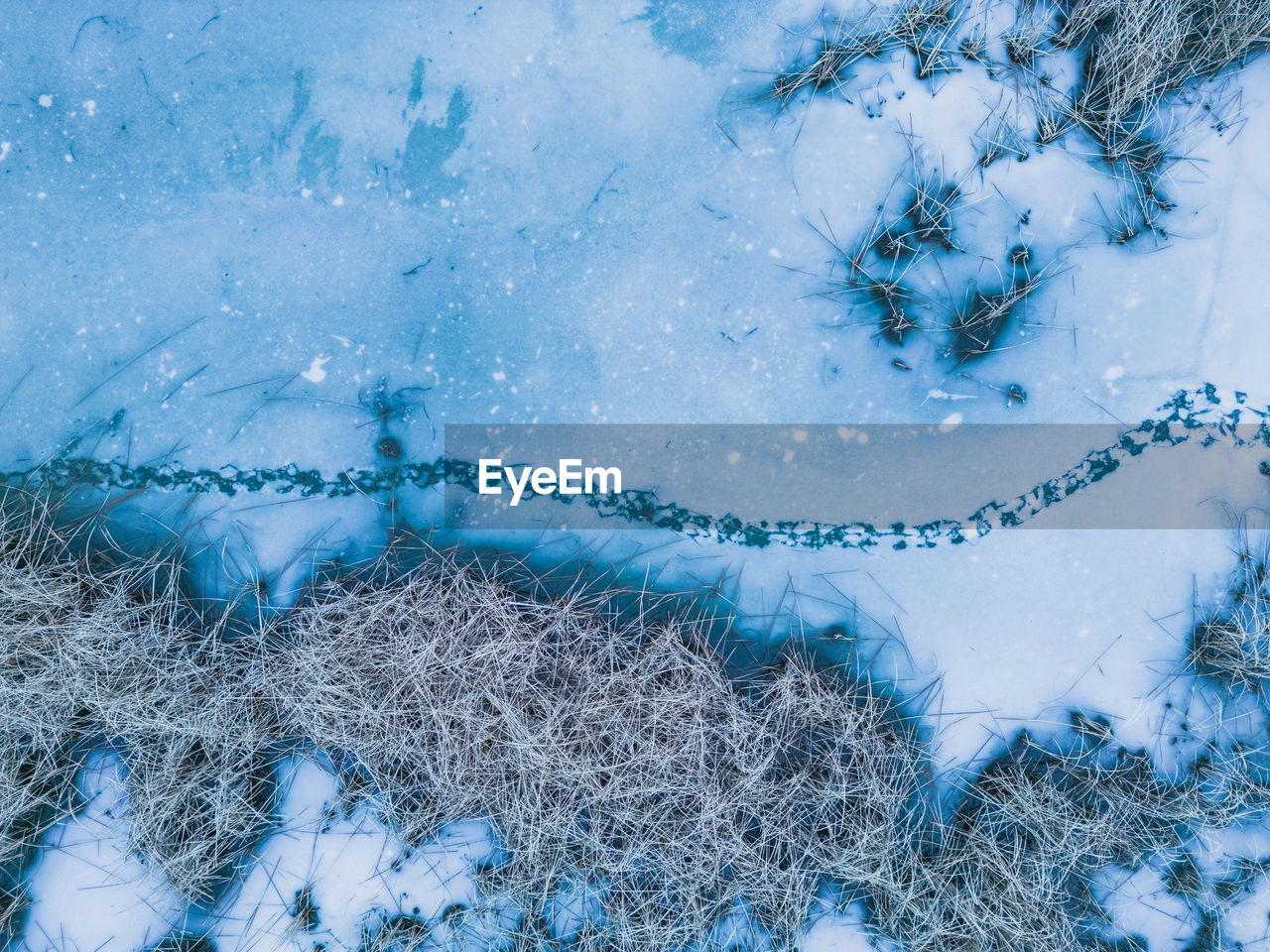 Panoramic aerial view of a frozen lake with animal footprints. animal tracks on the frozen surface 