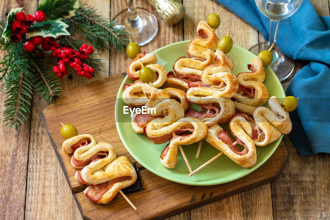 Christmas and new year food. holiday snack puff dough christmas tree with olive and bacon. 