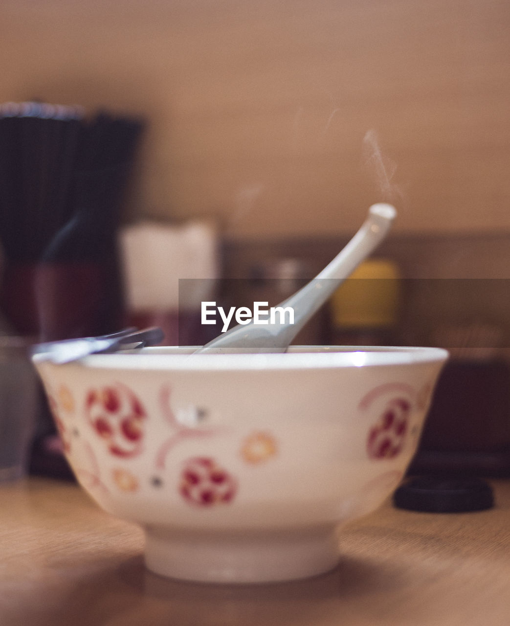 CLOSE-UP OF COFFEE CUP ON TABLE AGAINST WALL