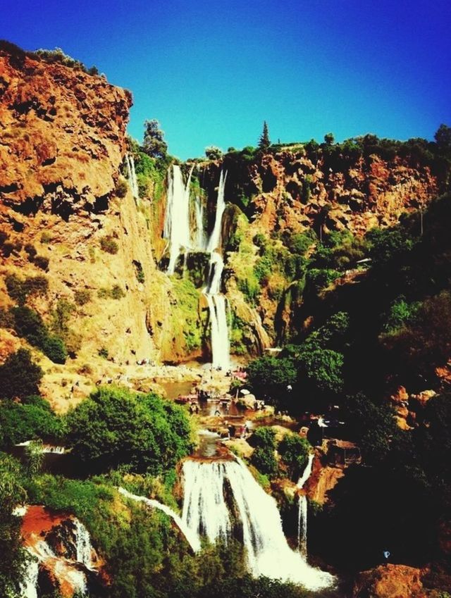 SCENIC VIEW OF WATERFALL AGAINST SKY