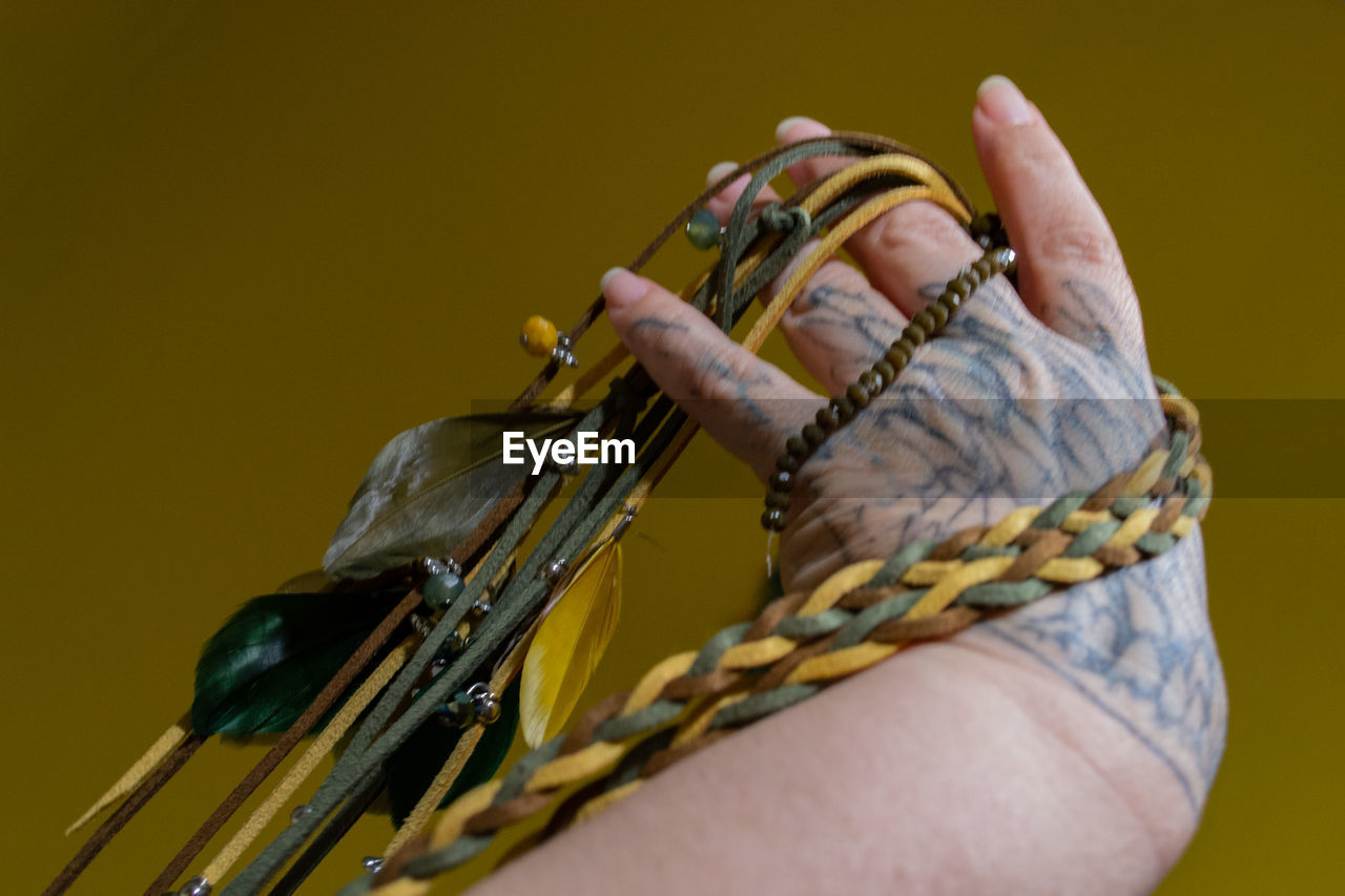 CLOSE-UP OF HAND HOLDING ROPE